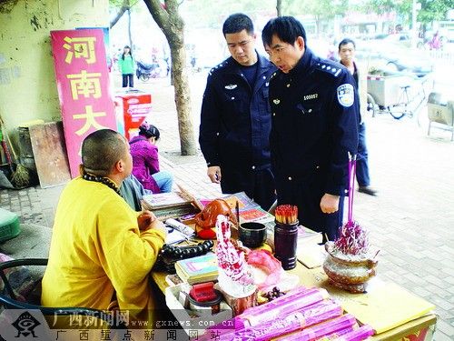 在南宁市人民路朝阳广场公交车站台旁,有一个算命摊长期摆着,其占卜